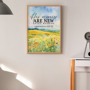May include: A framed watercolor painting with a field of flowers and the text "His mercies are new every morning" with the scripture reference "Lamentations 3:22-23".