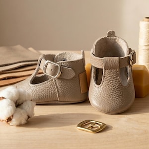 Handmade Stone Color Leather Baby T-Strap Shoes, Taş Rengi Deri Bebek T-Strap Ayakkabı, Zapatos T-strap de bebé en cuero color piedra, Steinfarbene Baby-T-Strap-Schuhe aus Leder, Chaussures T-strap bébé en cuir couleur pierre, Scarpine T-strap neonato in pelle color pietra, Steenkleurige leren baby T-strap schoentjes, 石头色真皮婴儿T型带鞋, ストーンカラー レザー ベビー Tストラップシューズ, स्टोन कलर लेदर बेबी टी-स्ट्रैप जूते, حذاء طفل جلدي بحزام تي لون حجر, Sapatinho T-strap de couro cor pedra para bebê, 스톤 컬러 가죽 아기 T스트랩 신발