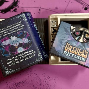 May include: A black and blue book with a picture of Ursula from The Little Mermaid. The book has the text "A powerful Ursula glimmer is entangling other glimmers, bending them to her will, while many more have gone missing." and "How far will the sea witch go to gain power over all of Lorcana?" The book is open to reveal a white box with a black and blue card that says "Ursula's Return" and has a spinning wheel with the text "20 Lorcana".