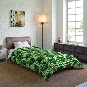 May include: A single bed featuring a green and white chevron patterned duvet cover decorated with repeating dark green heart shapes containing the Greek letters Phi Delta Phi in white text, paired with a plain white pillow.