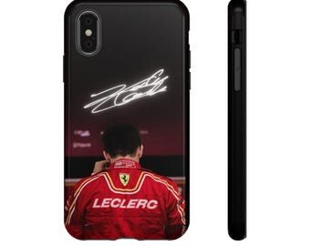 May include: Black phone case featuring a red and yellow racing suit with the name "LECLERC" on the back. The case has a black background with a neon signature. The phone case is black.