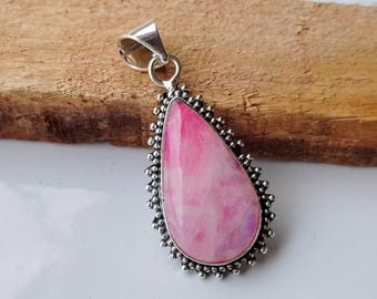 May include: A pink and white gemstone pendant with a silver setting. The pendant is shaped like a teardrop and has a delicate, ornate design.
