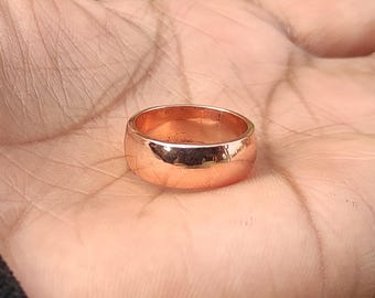 May include: A simple, polished copper ring with a rounded band.
