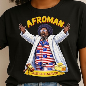 May include: Black t-shirt featuring a colorful illustration of Afroman, wearing a white coat, American flag suit, and sunglasses. The text "AFROMAN" is above the illustration, and "JUSTICE IS SERVED" is below.