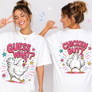 May include: White t-shirts with a playful chicken graphic. One shirt reads "GUESS WHAT?" with a cartoon chicken, the other says "CHICKEN BUTT" with a rear view of a chicken. Pink, blue, and yellow accents.