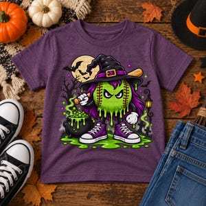 May include: A purple short-sleeve t-shirt featuring a graphic of a green baseball character with purple hair, wearing a black witch hat and purple sneakers, holding a baseball bat next to a black cauldron with green bubbling liquid.
