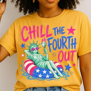 May include: A mustard yellow t-shirt featuring a graphic of the Statue of Liberty wearing pink sunglasses, lounging in a red, white, and blue star-patterned pool float while holding a martini. The text reads CHILL THE FOURTH OUT in pink and blue.