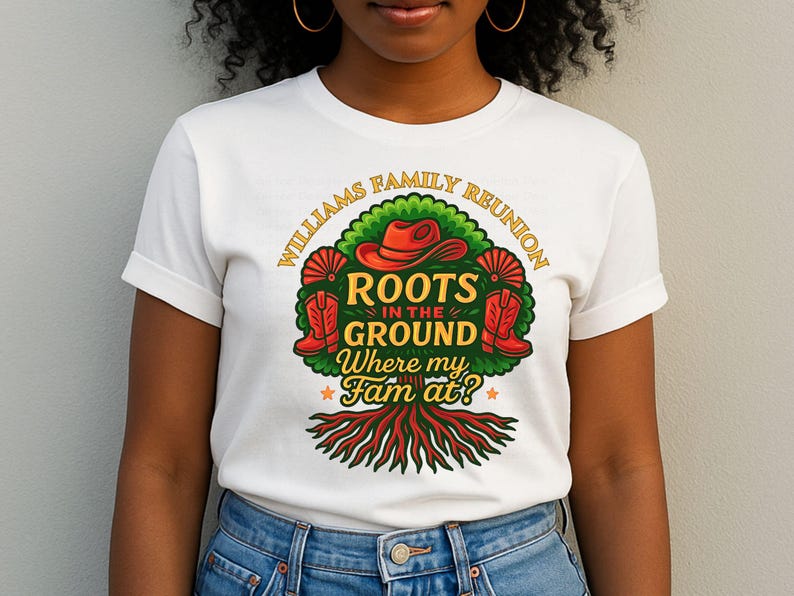 May include: White t-shirt featuring a colorful graphic design. The design includes a red cowboy hat, boots, and the text "Williams Family Reunion, Roots in the Ground, Where my Fam at?" in a circular arrangement around a tree.