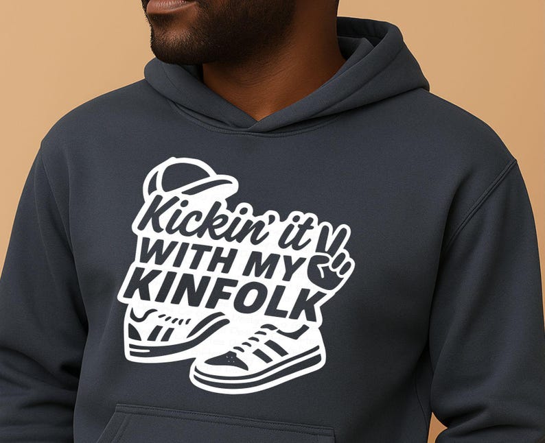 May include: Dark navy blue hoodie with a white graphic that says "Kickin' it with my Kinfolk". The graphic includes a baseball cap, sneakers, and a peace sign. The hoodie has a hood and a front pocket.