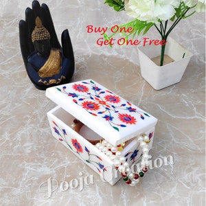 May include: White marble jewelry box with a floral design in red, blue, and green. The box is open and has a pearl necklace and a gold bangle inside. The text "Buy One Get One Free" is visible in the background.