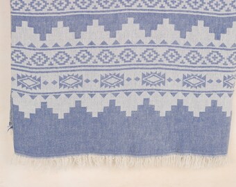 May include: Blue and white patterned textile with a geometric design. The fabric features a repeating pattern of diamonds, triangles, and other shapes. The bottom edge has a fringe.