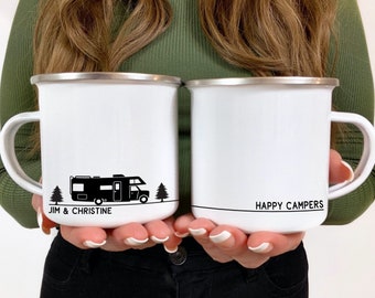 May include: Two white enamel camping mugs with black handles. The mug on the left has a black silhouette of a camper van, two trees, and the text "JIM & CHRISTINE". The mug on the right has the text "HAPPY CAMPERS".