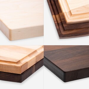 May include: A collection of wooden cutting boards in various stages of completion. The boards are made of light and dark wood, with some featuring a juice groove. The edges are smooth and rounded, showcasing the natural grain of the wood.
