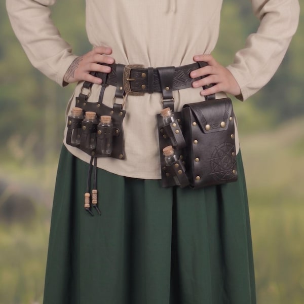 May include: A dark brown leather utility belt featuring an embossed geometric pattern, a brass buckle, and multiple attached leather pouches. The belt includes several small glass vials with cork stoppers held in leather loops and a larger rectangular pouch with a star-shaped embossed design.