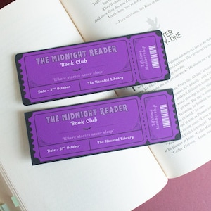May include: Two purple "The Midnight Reader Book Club" tickets with black trim and text, on an open book. The tickets have a vintage design with the text "Where stories never sleep" and "The Haunted Library".