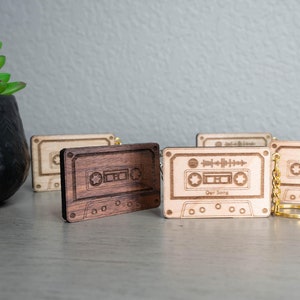 May include: Four wooden cassette tape keychains with gold chains. One keychain has the text "Our Song" engraved on it.