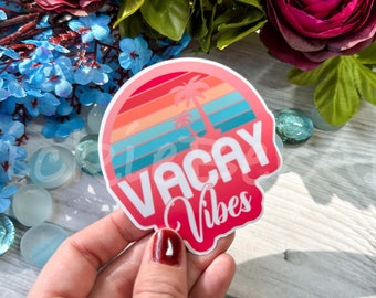 May include: A pink and white sticker with a sunset and palm trees graphic. The sticker says "Vacay Vibes" in white text.