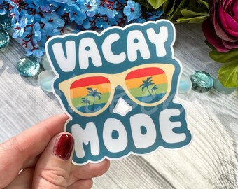 May include: A blue and white sticker with the text "Vacay Mode" and a pair of sunglasses with palm trees reflected in the lenses.
