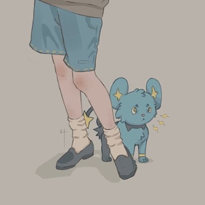 Puede incluir: Una persona joven con cabello castaño y gafas sostiene una pila de libros. Lleva un suéter marrón, pantalones cortos azules y calcetines blancos. Una criatura de dibujos animados azul y amarilla con una estrella en la cabeza está de pie a su lado.