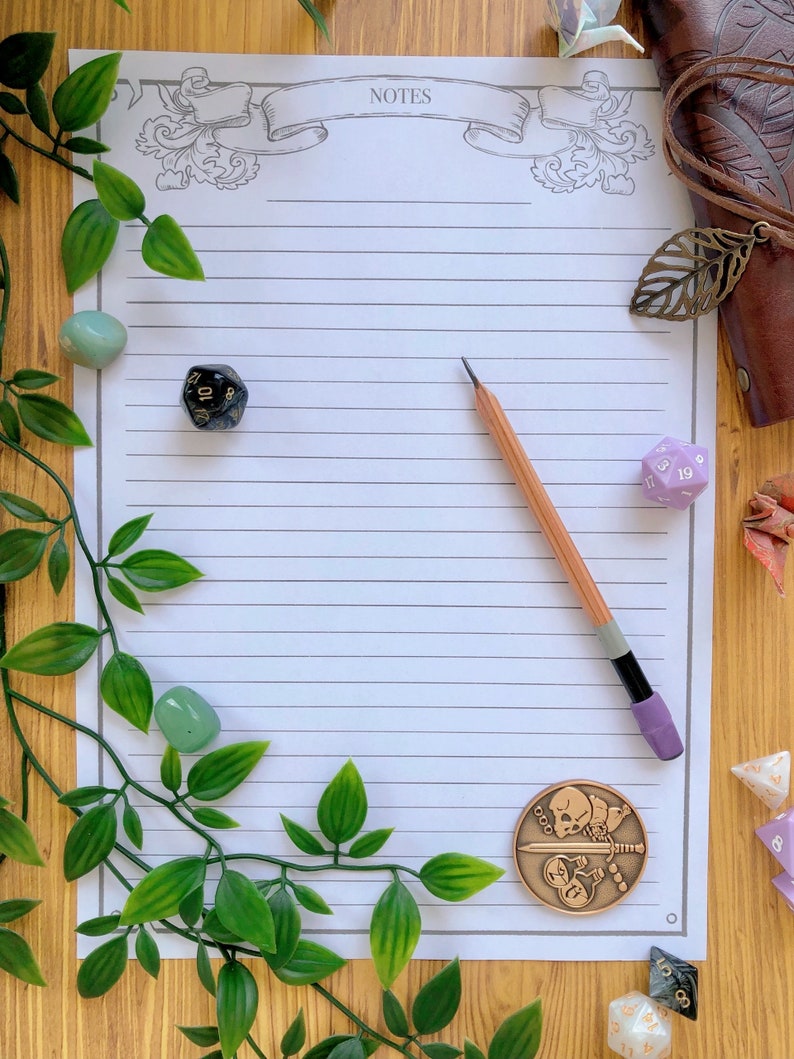 May include: A white lined paper with the word "NOTES" at the top, surrounded by a decorative border. A pencil, a green leafy vine, and several dice are scattered around the paper.