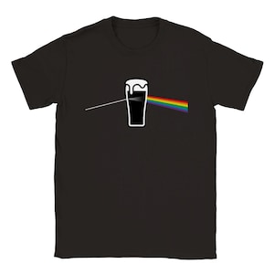 以下が含まれることがあります： 黒いTシャツ。白い泡、白い線、虹色のプリズムデザインのビールジョッキのグラフィック。デザインはシャツの前面の中央に配置されています。