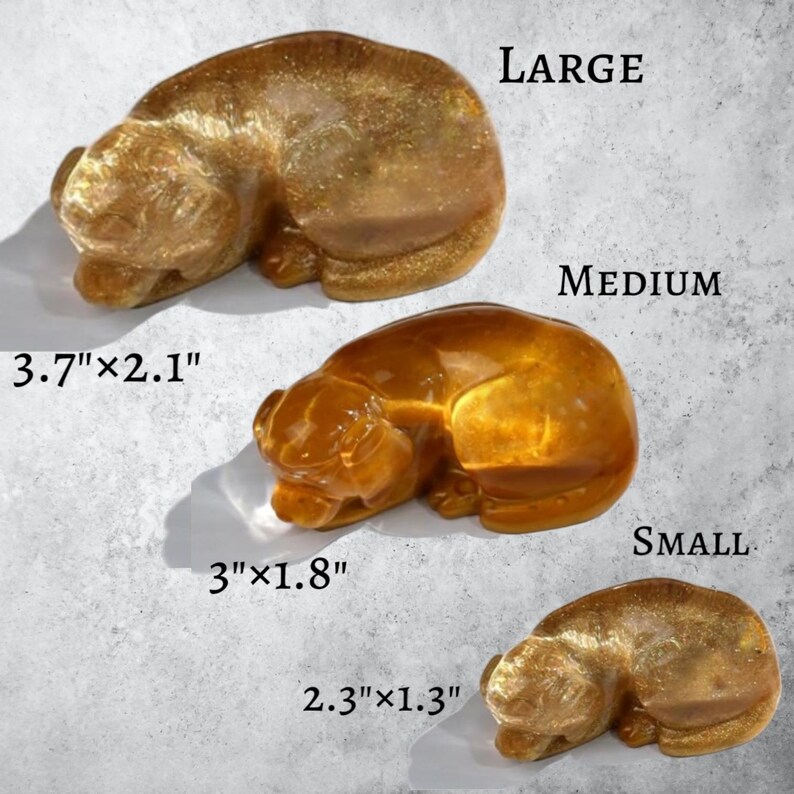 Pode incluir: Tr&ecirc;s estatuetas de cachorro dourado a dormir em tamanhos diferentes: grande, m&eacute;dio e pequeno. A estatueta grande mede 9,4 cm por 5,3 cm, a estatueta m&eacute;dia mede 7,6 cm por 4,6 cm e a estatueta pequena mede 5,8 cm por 3,3 cm.