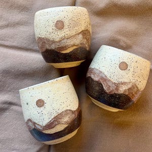 Taza de cerámica de montaña con cielo cálido