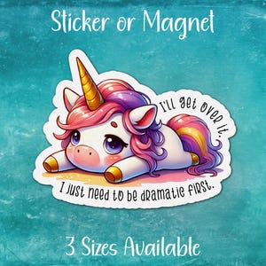 May include: A sticker or magnet featuring a cartoon unicorn with pink and purple hair, lying on its side with the text "I'll get over it. I just need to be dramatic first."