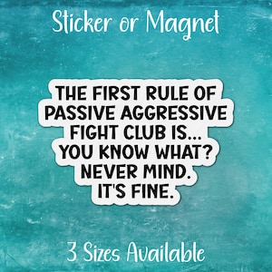 May include: White sticker or magnet with black text that reads "The first rule of passive aggressive fight club is... You know what? Never mind. It's fine."  The text is centered on the sticker.  The sticker is on a blue background.  3 Sizes Available is written in black text at the bottom of the image.