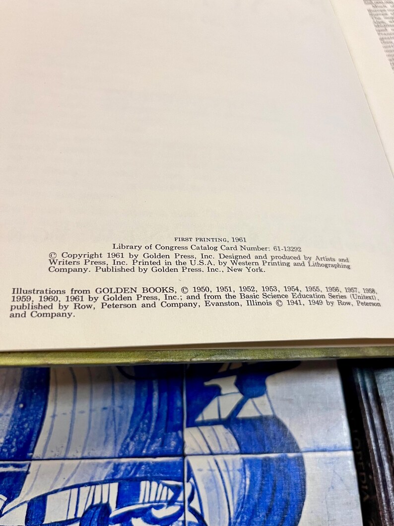 May include: Open book page with text from Golden Press, Inc. The text includes copyright information, Library of Congress Catalog Card Number, and printing details. The page is set against a blue and white tile background.