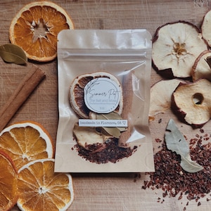 Pode incluir: Um pequeno saco de plástico transparente cheio de fruta seca, especiarias e uma folha de louro. O saco é etiquetado com "Summer Pot, The Salt and Spice", "1 oz" e "handmade in Florence, OR".