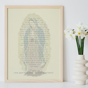 May include: A framed print with a yellow background featuring a religious image of Our Lady of Guadalupe with a text excerpt from her message to St. Juan Diego. The text reads "Dear little son, I love you. I want you to know who I am. I am the ever-Virgin Mary, Mother of the true God who gives life. I am your merciful Mother, the Mother of all who live united in this land and of all mankind, and of all those who love me of those who cry to me of those who have confidence in me. Here, I will hear their weeping and their sorrows and will remedy and alleviate their sufferings, necessities and misfortunes. Listen, and let it penetrate into your heart, my dear little son. Do not be troubled or weighed down with grief. Do not fear any illness or vexation, anxiety or pain. Am I not your Mother? Are you not under my shadow and protection? Am I not your fountain of life? Are you not in the folds of my mantle? In the crossing of my arms? Is there anything else you need? Our Lady of Guadalupe to St. Juan Diego."