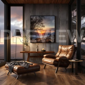 Puede incluir: Un sill&oacute;n de cuero marr&oacute;n con un coj&iacute;n se encuentra en una sala de estar con una gran ventana que da a una masa de agua. Una fotograf&iacute;a de paisaje enmarcada cuelga en la pared detr&aacute;s del sill&oacute;n. Una mesa de caf&eacute; de madera con un jarr&oacute;n de vegetaci&oacute;n se encuentra frente al sill&oacute;n.