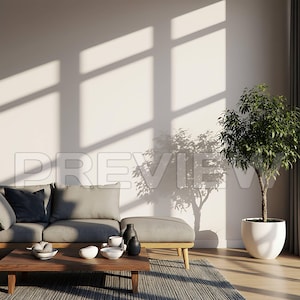 May include: A modern living room with a gray sofa, ottoman, and wooden coffee table. Decorative bowls and vases are arranged on the table. A potted tree sits in the corner, and sunlight streams through a window.