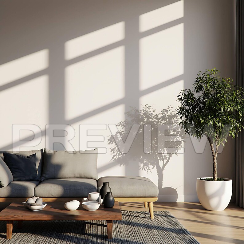 May include: A modern living room with a gray sofa, ottoman, and wooden coffee table. Decorative bowls and vases are arranged on the table. A potted tree sits in the corner, and sunlight streams through a window.
