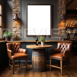 May include: A rustic bar setting with two brown leather chairs, a wooden barrel table, and a framed blank canvas on the wall. A bottle of wine and a potted plant are on the table.