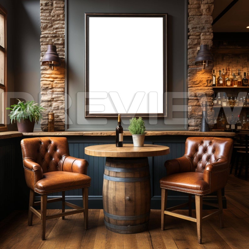 May include: A rustic bar setting with two brown leather chairs, a wooden barrel table, and a framed blank canvas on the wall. A bottle of wine and a potted plant are on the table.