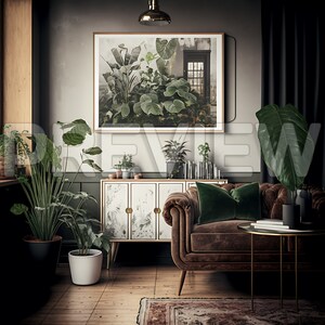 May include: A living room interior with a brown velvet sofa, a green velvet throw pillow, a gold metal side table, and a white cabinet with gold accents. A framed print of lush green plants hangs on the wall above the cabinet.