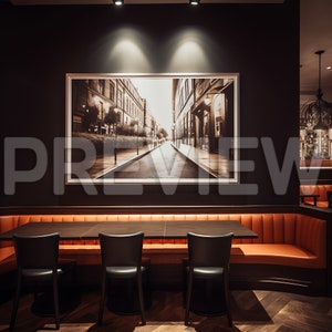 May include: A black framed photograph of a city street with buildings on either side, hanging on a dark wall above a long, orange leather banquette with four black chairs. The banquette and chairs are arranged around a dark wood table.
