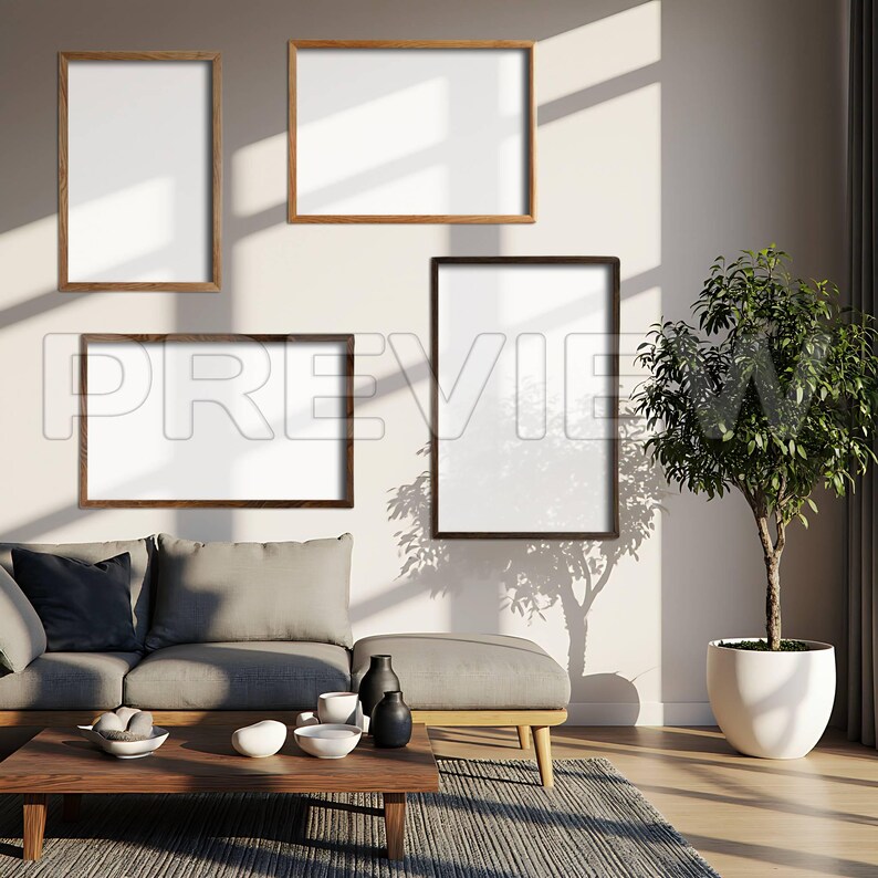 May include: Four framed art pieces with white interiors are mounted on a light-colored wall. The frames are in various sizes and colors, including light and dark wood. A sofa, ottoman, and coffee table are in the foreground, with a potted plant to the right.
