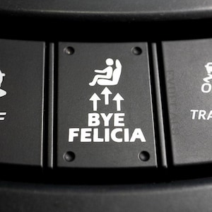 May include: Three black buttons with white text and symbols. The left button says "OFF" and has a car icon with wavy lines underneath. The middle button says "BYE FELICIA" and has an arrow pointing up. The right button says "TRACK" and has a car icon with a checkered flag.