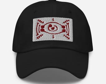May include: Black baseball cap with a rectangular embroidered patch. The patch features a white background with a red, stylized design in the center. The cap has a curved brim and an adjustable strap.