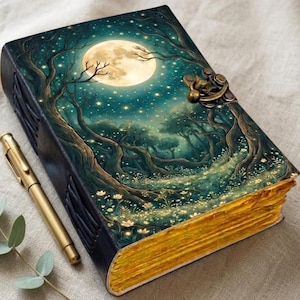 May include: A rectangular journal with a dark cover featuring a full moon, starry sky, and forest scene. The book has a metallic latch closure and thick, yellow-toned pages with a deckled edge. A gold-colored metal pen lies beside the journal.