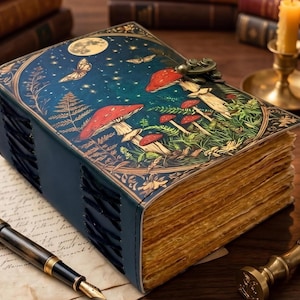 Puede incluir: Un diario rectangular con una cubierta azul oscuro que presenta una ilustración impresa de setas rojas, mariposas y un cielo estrellado a la luz de la luna. El libro tiene un cierre de pestillo metálico y páginas gruesas con bordes.