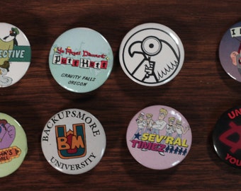May include: A set of ten round pins with various designs and text. The pins feature characters and logos from the animated television series Gravity Falls. The pins are colorful and feature a variety of designs, including a duck detective, a gnome, a bear, a bird, and a university logo.