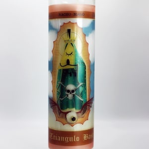 May include: A tall cylindrical glass prayer candle featuring a graphic label with a yellow triangular character wearing a crown, a green cloak, a skull and crossbones, and a single eye at the base. The text NACHO MALO and Triangulo Malo appear.