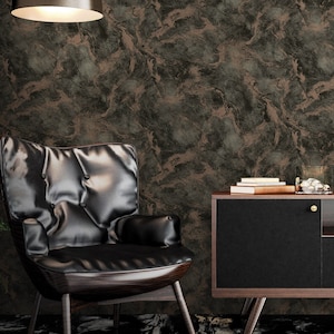 K&ouml;nnte beinhalten: Ein schwarzer Ledersessel mit einer gesteppten R&uuml;ckenlehne und einem dunklen Holzrahmen steht vor einer Wand mit einer braunen und gr&uuml;nen Marmortapete. Rechts vom Sessel steht ein schwarzer Schrank mit einer Holzplatte und goldenen Kn&ouml;pfen.