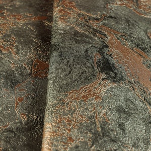 K&ouml;nnte beinhalten: Nahaufnahme eines Stoffes mit Marmorierung in Graut&ouml;nen, Braun und Kupfer. Der Stoff hat eine strukturierte Oberfl&auml;che.