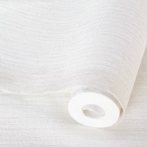 May include: A close-up of a white wallpaper roll with a textured surface. The roll is partially unrolled, revealing the wallpaper's pattern.