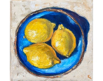 May include: An oil painting depicts three yellow lemons in a deep blue bowl. The bowl has a brown rim and sits on a beige background. The artwork is a still life, with visible brushstrokes adding texture.
